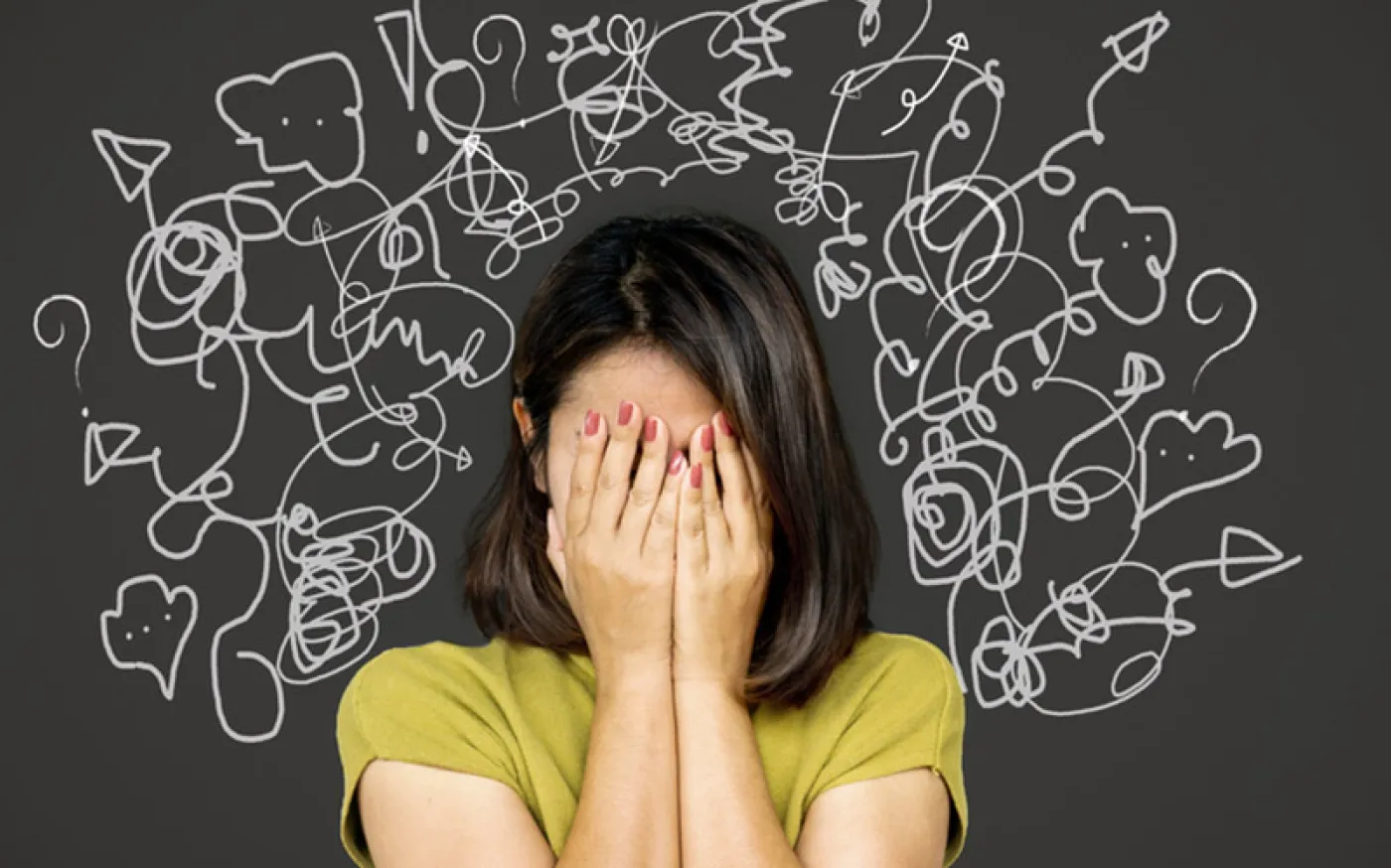 A woman with her head in her hands, her mind in chaos, having many thoughts at once
