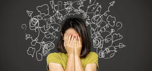 A woman with her head in her hands, her mind in chaos, having many thoughts at once